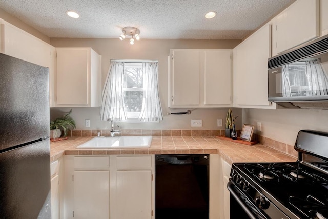 kitchen featuring a textured ceiling, recessed lighting, a sink, white cabinets, and black appliances