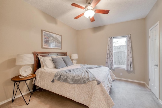 carpeted bedroom featuring a ceiling fan, a textured ceiling, and baseboards