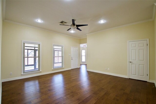 empty room featuring baseboards, visible vents, dark wood finished floors, a ceiling fan, and ornamental molding