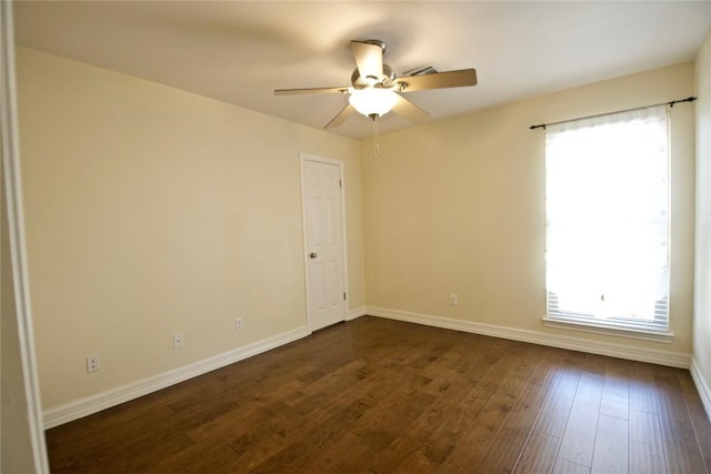 spare room with ceiling fan, baseboards, and dark wood-style flooring