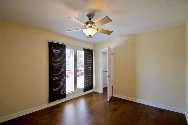 spare room featuring dark wood-style floors, a wealth of natural light, and baseboards