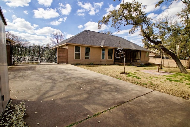 back of property with a shingled roof and fence