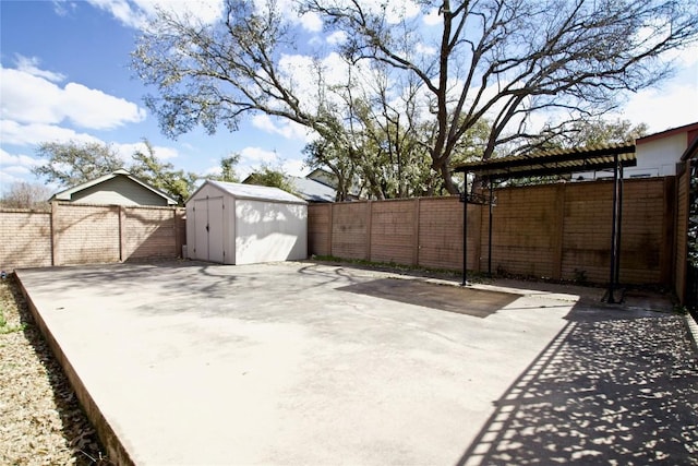 view of patio / terrace with an outbuilding, a fenced backyard, and a shed