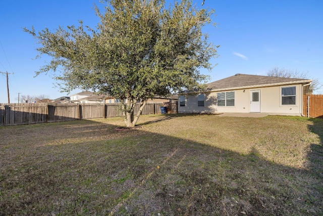 rear view of property featuring a yard, a patio area, a fenced backyard, and stucco siding