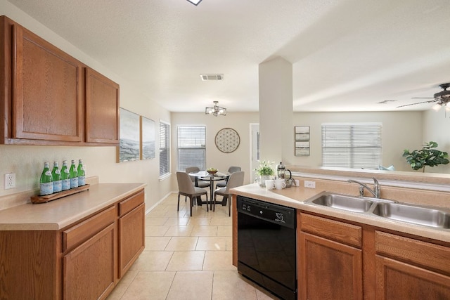 kitchen with light tile patterned floors, visible vents, dishwasher, light countertops, and a sink