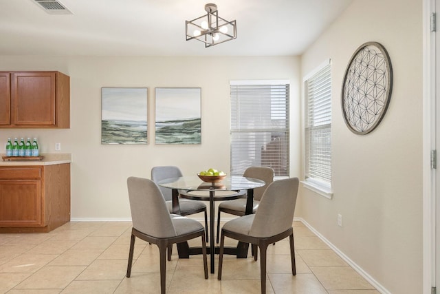 dining space with a chandelier, visible vents, baseboards, and light tile patterned flooring