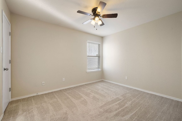 empty room with carpet floors, baseboards, and a ceiling fan