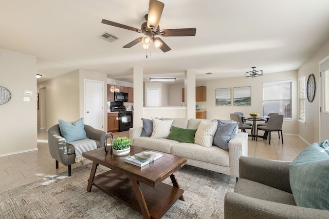 living room with a ceiling fan, light tile patterned flooring, visible vents, and baseboards