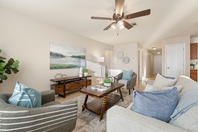 living area with visible vents and ceiling fan