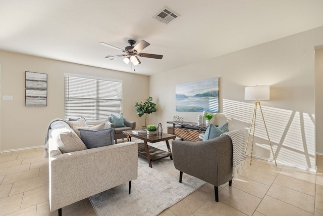 living room featuring light tile patterned floors, baseboards, visible vents, and a ceiling fan