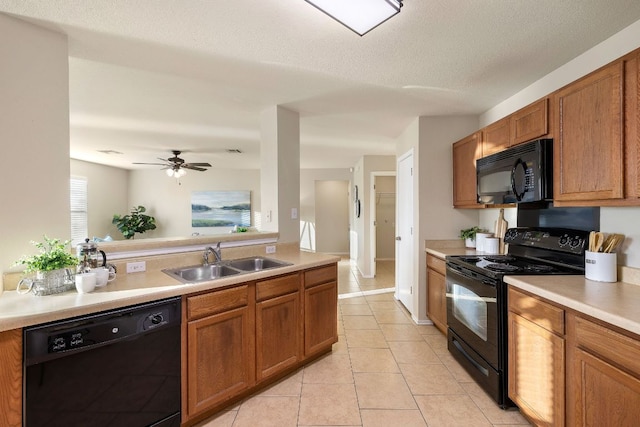 kitchen with brown cabinetry, light countertops, a sink, and black appliances