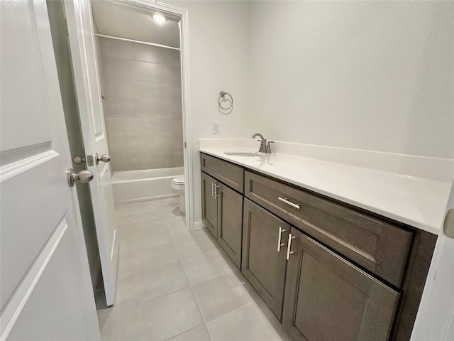 bathroom featuring tile patterned floors, toilet, vanity, and bathing tub / shower combination