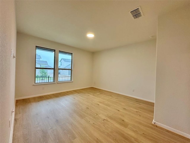 empty room featuring light wood-type flooring, baseboards, and recessed lighting