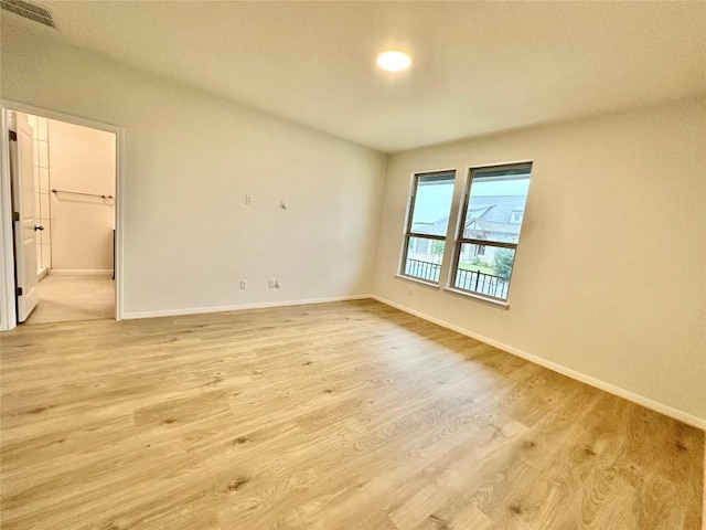 spare room with light wood-style flooring and baseboards