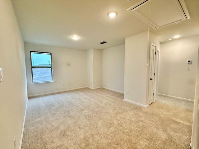 unfurnished room featuring attic access, light colored carpet, baseboards, and recessed lighting