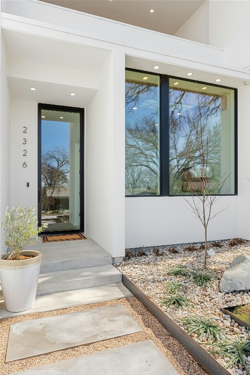 doorway to property featuring stucco siding