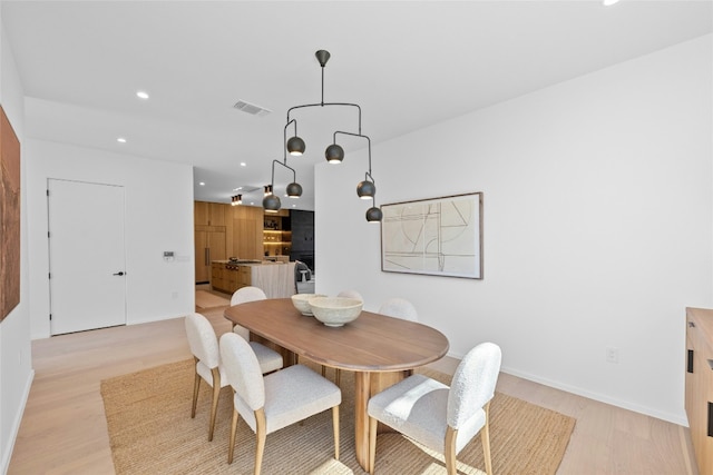 dining room featuring baseboards, light wood-style floors, visible vents, and recessed lighting