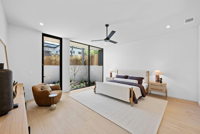 bedroom featuring recessed lighting, visible vents, expansive windows, wood finished floors, and access to outside