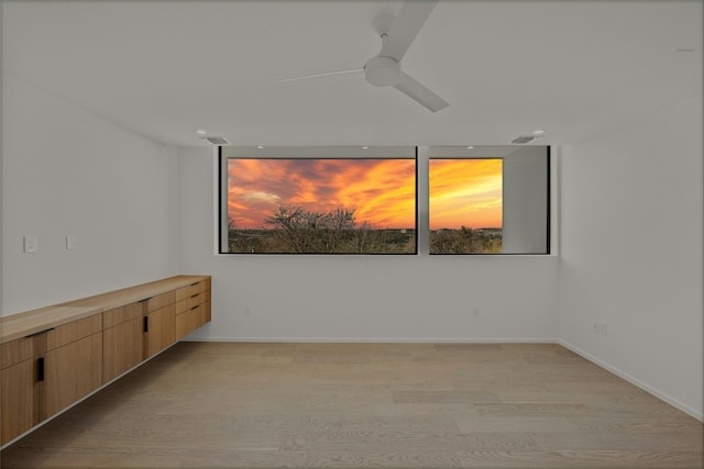 empty room with ceiling fan, baseboards, visible vents, and light wood-style floors