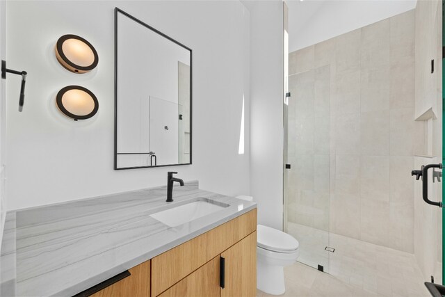 bathroom with vanity, tile patterned flooring, a shower stall, and toilet