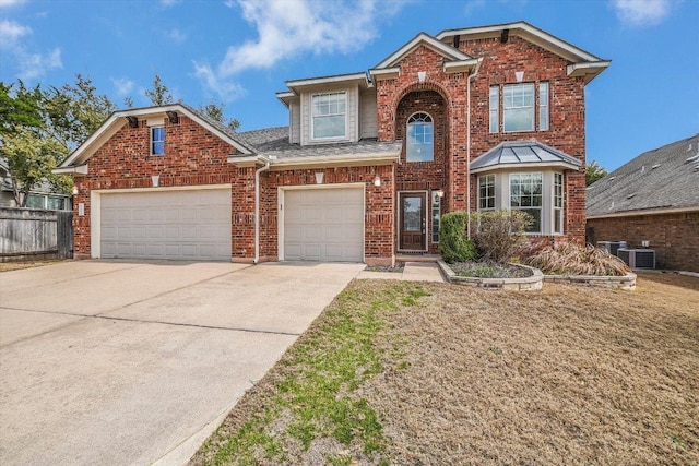 traditional home featuring an attached garage, central air condition unit, brick siding, fence, and concrete driveway