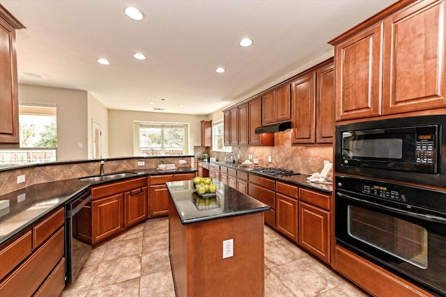 kitchen with backsplash, a kitchen island, a sink, under cabinet range hood, and black appliances