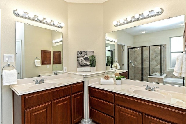 bathroom with a stall shower, two vanities, and a sink