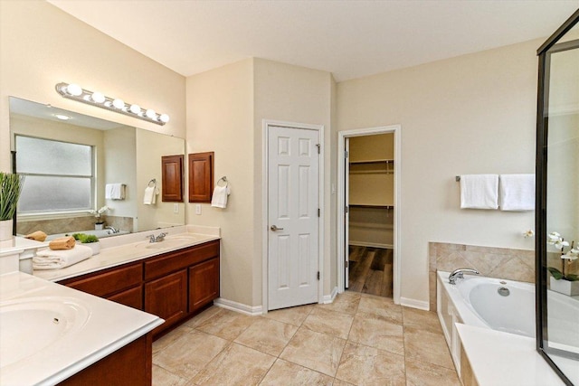 full bath with baseboards, a walk in closet, a bath, and vanity