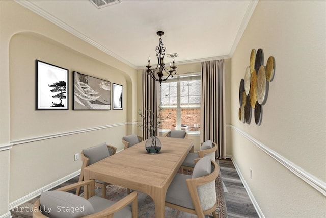 dining area featuring wood finished floors, visible vents, baseboards, ornamental molding, and an inviting chandelier