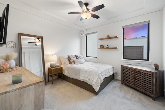 bedroom with a ceiling fan and light colored carpet