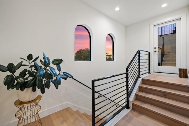 stairway featuring baseboards, wood finished floors, and recessed lighting