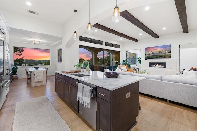 kitchen featuring decorative light fixtures, visible vents, a sink, dark brown cabinets, and dishwasher