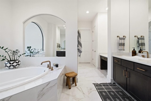 full bath featuring marble finish floor, a garden tub, vanity, and recessed lighting