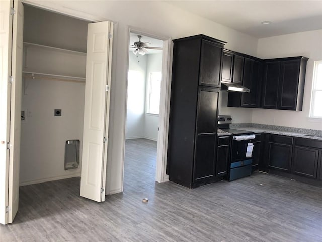 kitchen with light wood-type flooring, electric stove, plenty of natural light, and under cabinet range hood