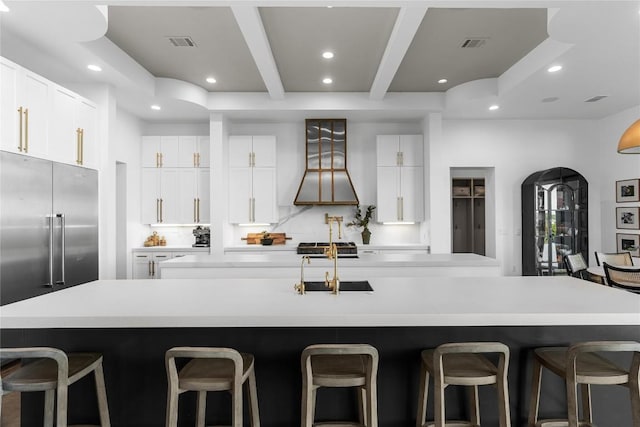 kitchen featuring beam ceiling, a spacious island, light countertops, visible vents, and backsplash