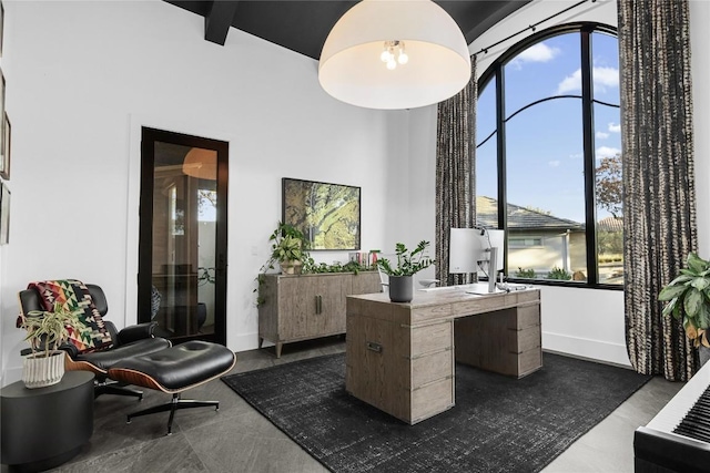 office space featuring a towering ceiling and baseboards