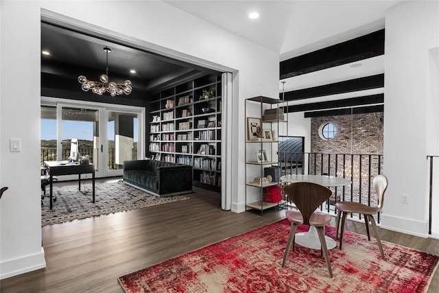 living area featuring baseboards, built in features, wood finished floors, an inviting chandelier, and beam ceiling