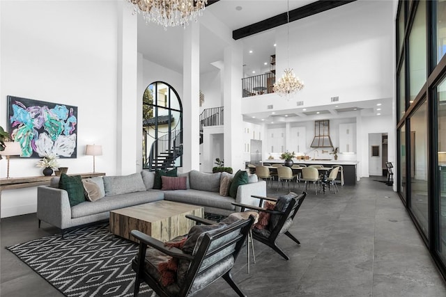 living room with visible vents, an inviting chandelier, stairs, a high ceiling, and beam ceiling