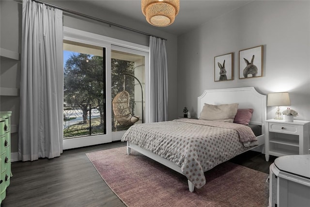 bedroom with dark wood-style floors and access to exterior