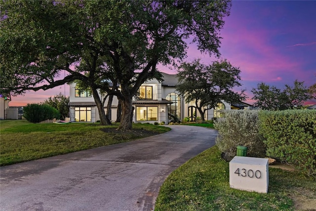 view of front facade with a yard and driveway