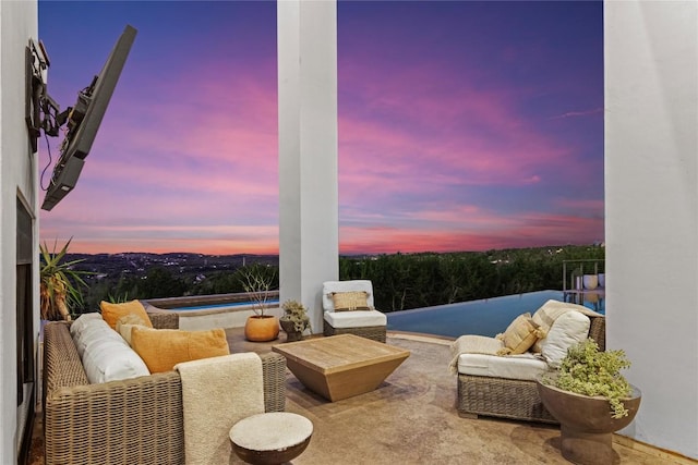 patio terrace at dusk featuring an in ground hot tub and outdoor lounge area