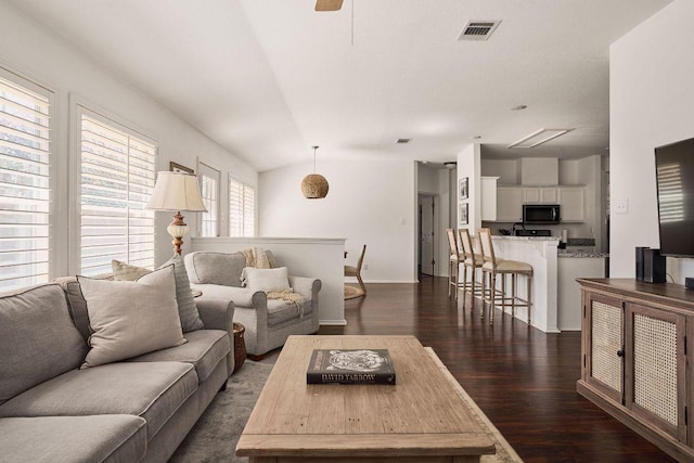 living room with lofted ceiling, visible vents, and dark wood-type flooring