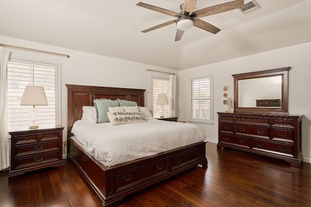 bedroom with lofted ceiling, dark wood-style floors, visible vents, and a ceiling fan