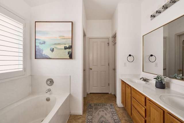 bathroom with tile patterned floors, a garden tub, a sink, and double vanity