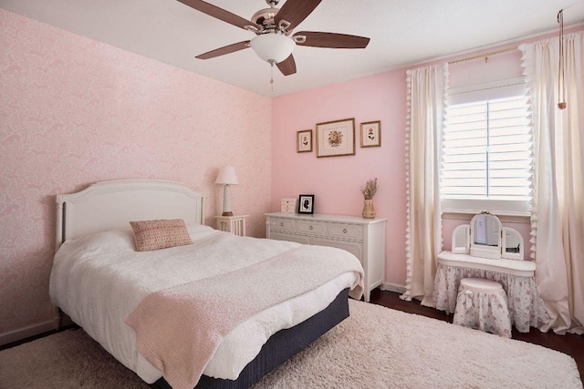 bedroom with ceiling fan, wallpapered walls, and baseboards