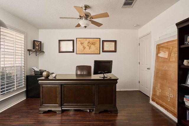 office featuring ceiling fan, a textured ceiling, dark wood finished floors, and visible vents