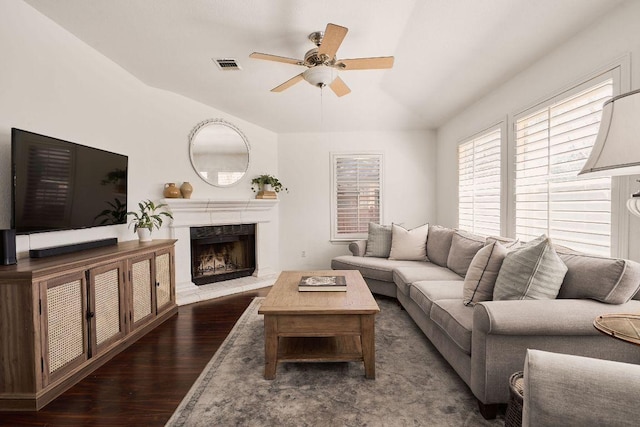 living room featuring ceiling fan, visible vents, wood finished floors, and a high end fireplace