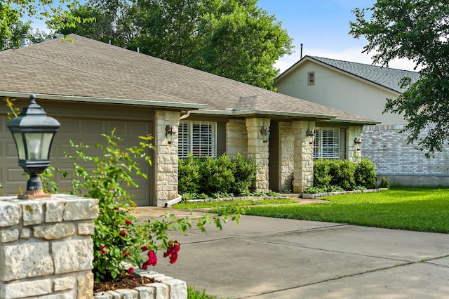 ranch-style house featuring driveway, stone siding, roof with shingles, an attached garage, and a front lawn