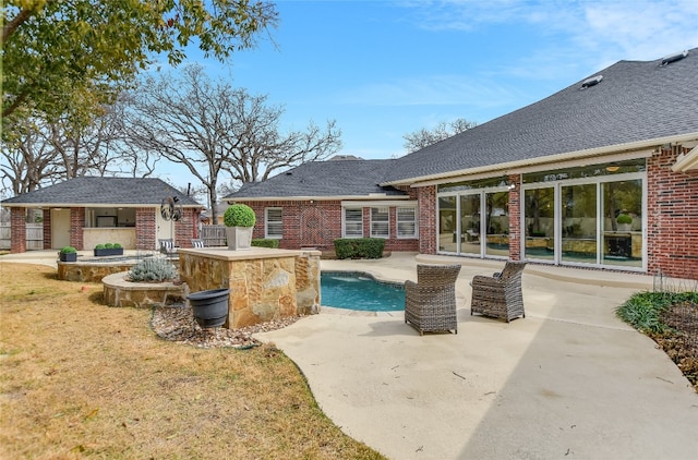 exterior space featuring a patio area, a lawn, and an outbuilding