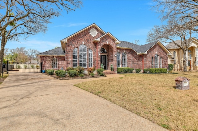 view of front facade with brick siding, a shingled roof, concrete driveway, a gate, and a front lawn